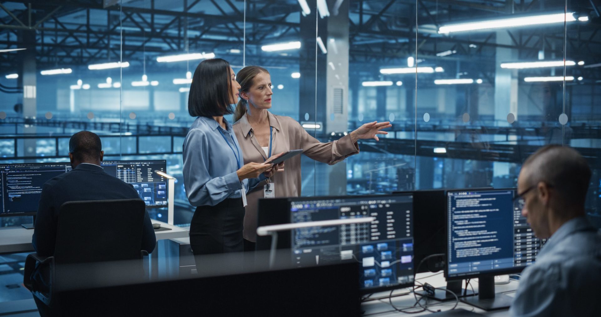 Two consultants Work Side by Side on a Tablet Computer in a Data Center Office, Conducting an inspection