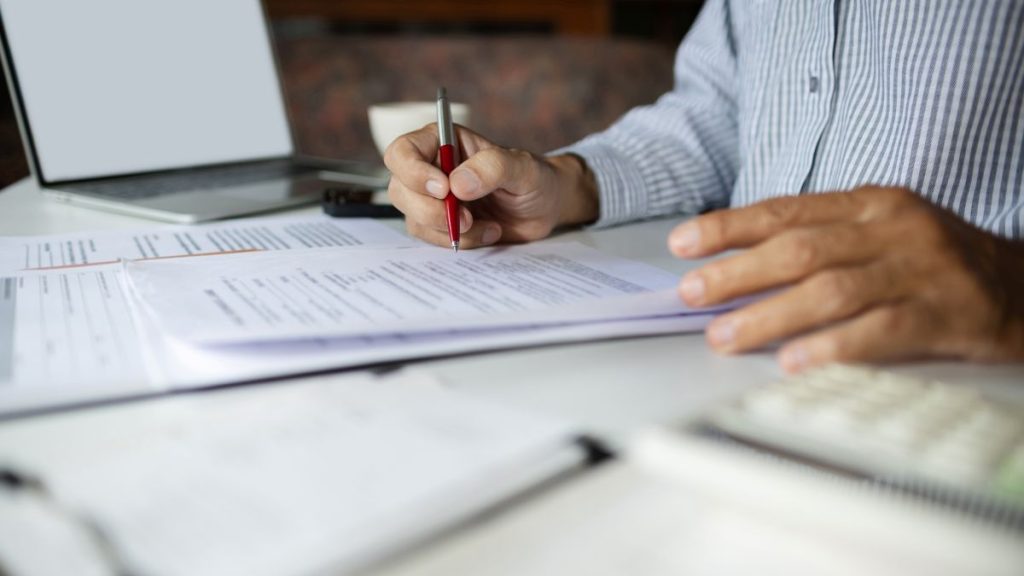 a mid close up of an HR professional analysing an employment contract for clawback clauses